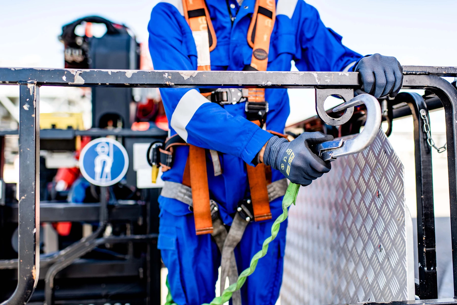 Close-up of an employee wearing work clothes and a safety harness