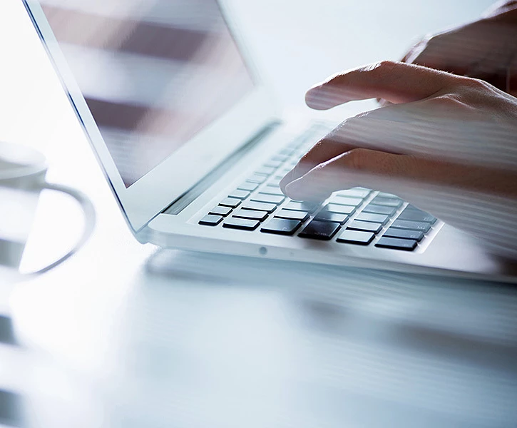 Close-up of hands typing on a laptop