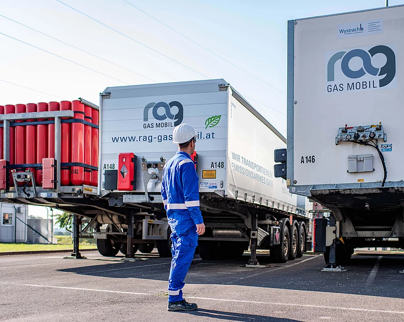 RAG employees in protective clothing in front of two trucks with RAG branding from behind