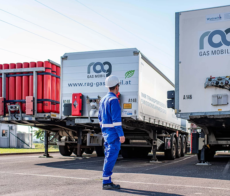 RAG employees in protective clothing in front of two trucks with RAG branding from behind