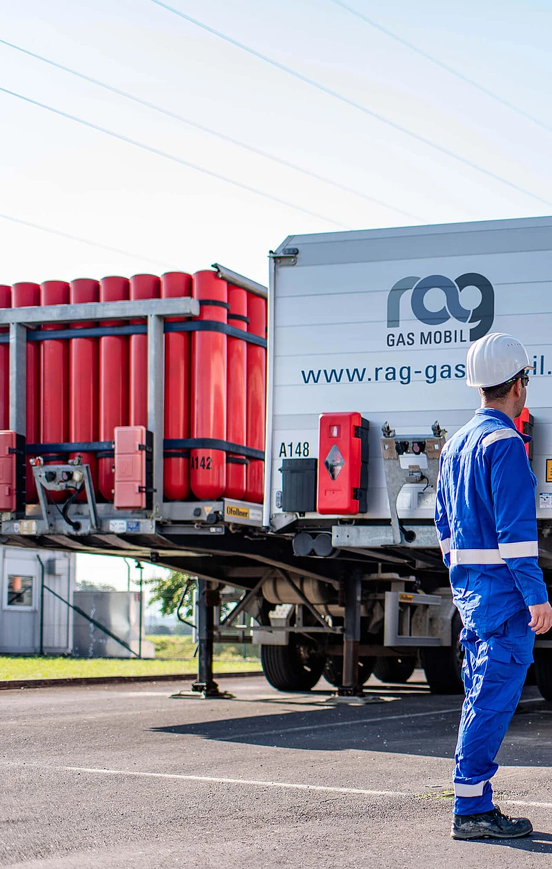 RAG employees in protective clothing in front of two trucks with RAG branding from behind