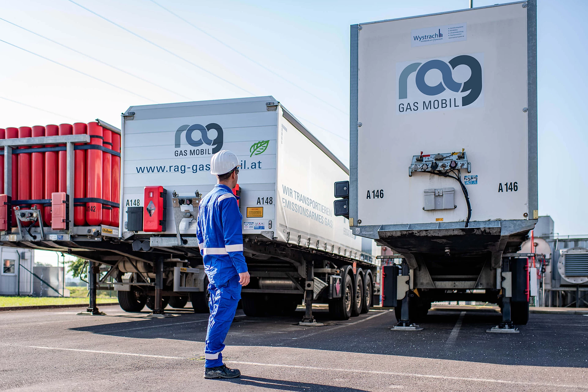 RAG employees in protective clothing in front of two trucks with RAG branding from behind